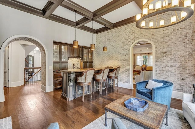 4317 Oglethorpe Loop NW, Acworth, GA 30101 - living room featuring arched walkways, dark wood-type flooring, bar area, beamed ceiling, and a high ceiling