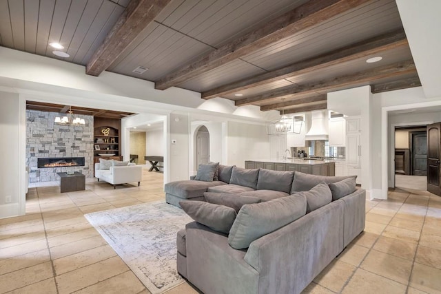 4317 Oglethorpe Loop NW, Acworth, GA 30101 - living area with a chandelier, built in features, a fireplace, a wooden ceiling with exposed beams, and arched walkways