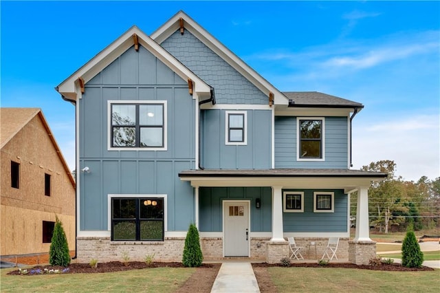 view of front of home featuring a porch, board and batten siding, and a front yard