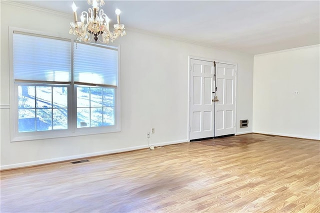 unfurnished room featuring ornamental molding, light hardwood / wood-style floors, and a notable chandelier