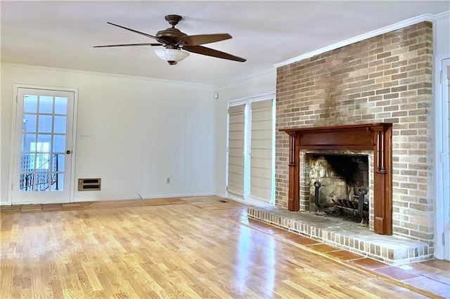 unfurnished living room featuring a brick fireplace, ornamental molding, ceiling fan, and light wood-type flooring