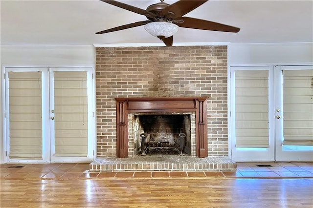 details featuring hardwood / wood-style flooring, a brick fireplace, french doors, and ceiling fan