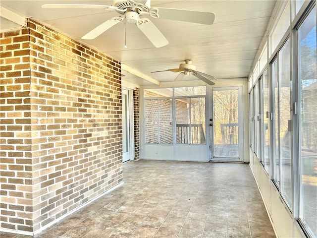 unfurnished sunroom with ceiling fan