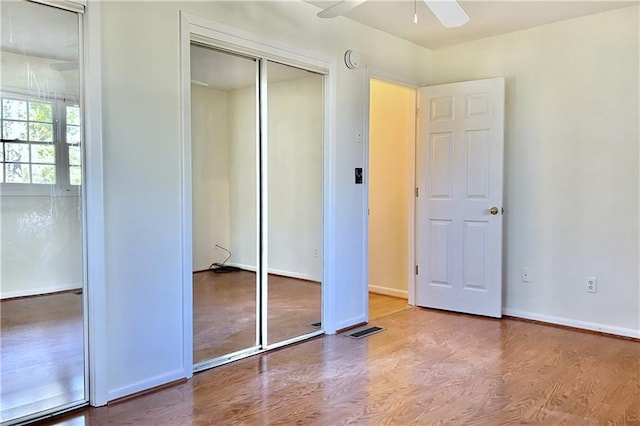 unfurnished bedroom featuring ceiling fan, a closet, and hardwood / wood-style floors