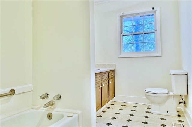 bathroom with toilet, vanity, and a tub