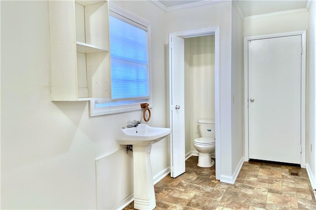 bathroom with toilet, sink, and crown molding