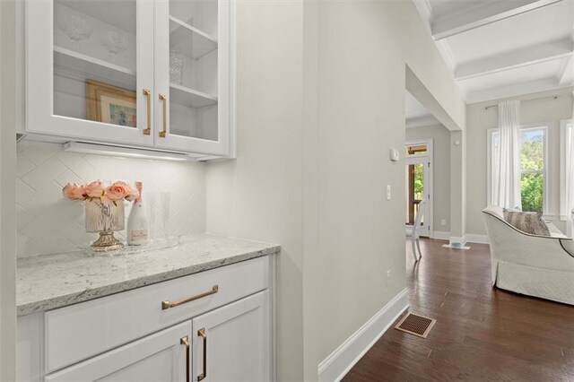 bar featuring visible vents, decorative backsplash, beam ceiling, baseboards, and dark wood-style floors