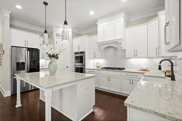kitchen with a sink, white cabinetry, appliances with stainless steel finishes, and a kitchen island