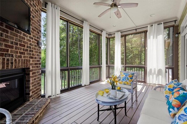 sunroom / solarium with french doors, a fireplace, and a ceiling fan