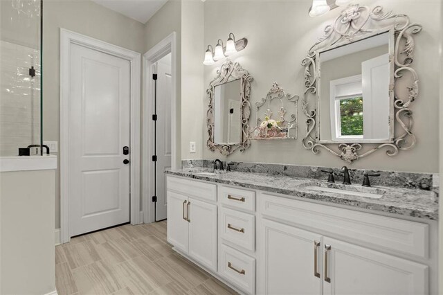 bathroom featuring double vanity, a sink, and a stall shower