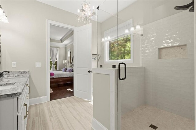 ensuite bathroom featuring an inviting chandelier, baseboards, ensuite bath, and a shower stall