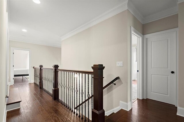 hall with crown molding, dark wood-style floors, and an upstairs landing