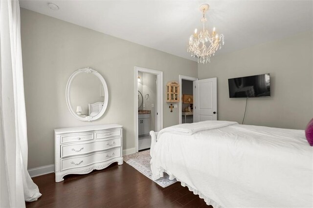 bedroom with baseboards, ensuite bath, wood finished floors, and a chandelier
