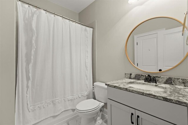 bathroom featuring vanity, marble finish floor, shower / bathtub combination with curtain, and toilet
