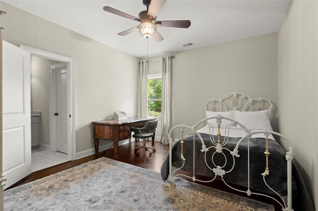 bedroom featuring baseboards, a ceiling fan, wood finished floors, and visible vents