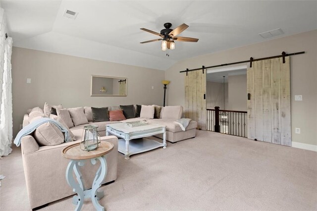 living room with visible vents, carpet floors, a barn door, a ceiling fan, and vaulted ceiling