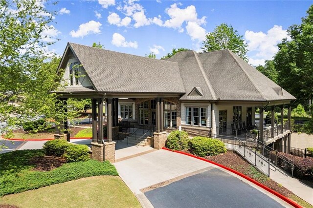 exterior space with a shingled roof and a patio area