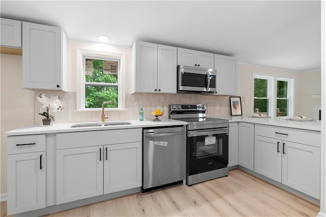1010 Martin Ln, Canton, GA 30114 - kitchen with stainless steel appliances, light wood-style floors, decorative backsplash, and healthy amount of natural light