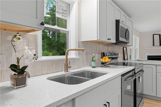 1010 Martin Ln, Canton, GA 30114 - kitchen with appliances with stainless steel finishes, tasteful backsplash, light stone countertops, and white cabinetry