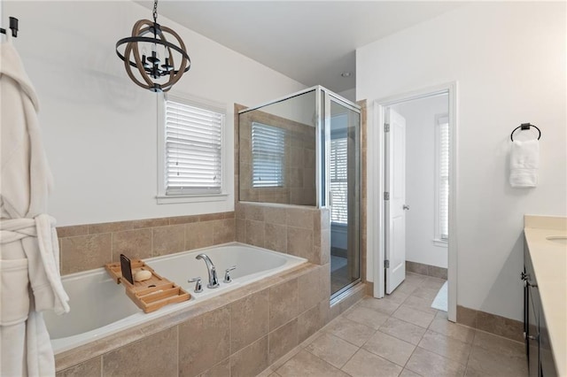 bathroom featuring a chandelier, a stall shower, a garden tub, tile patterned floors, and vanity