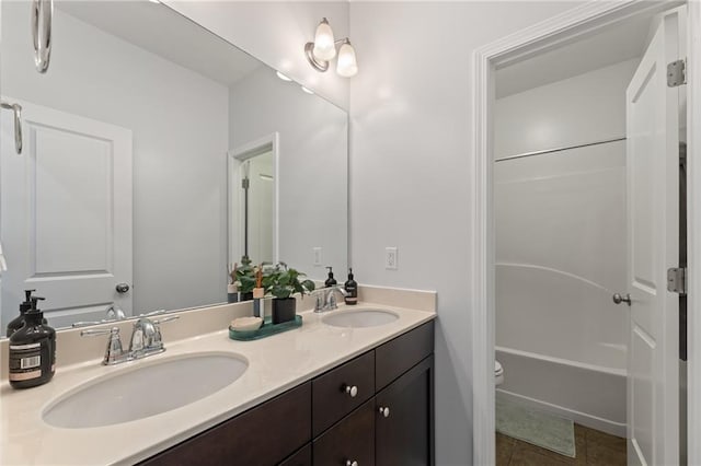 bathroom with double vanity, toilet, tile patterned flooring, and bathtub / shower combination