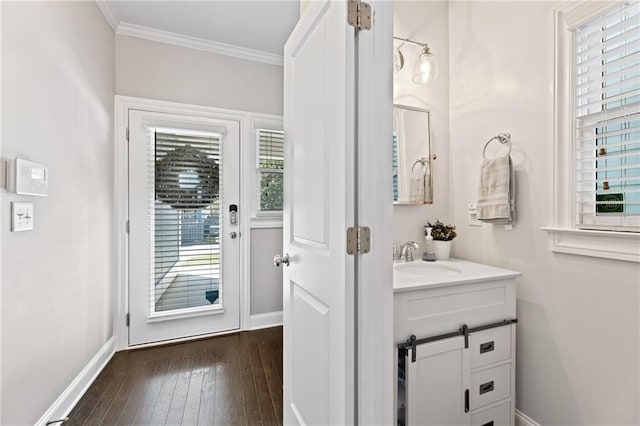 bathroom with baseboards, crown molding, hardwood / wood-style flooring, and vanity