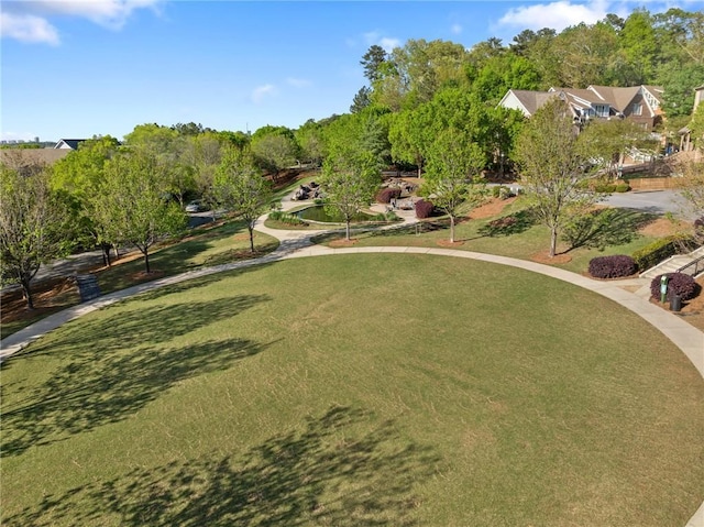 surrounding community featuring a lawn and view of scattered trees