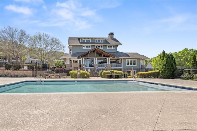 community pool with fence and a patio area