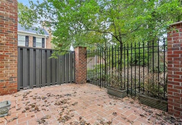 view of gate with a patio