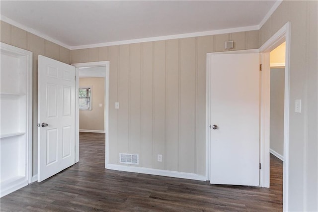 unfurnished bedroom featuring dark wood-type flooring and ornamental molding