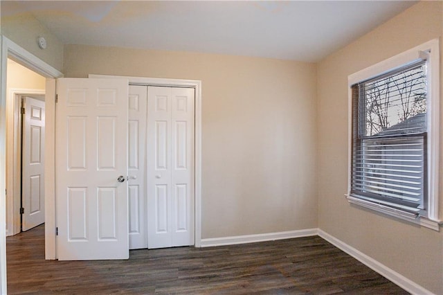 unfurnished bedroom featuring dark hardwood / wood-style flooring and a closet