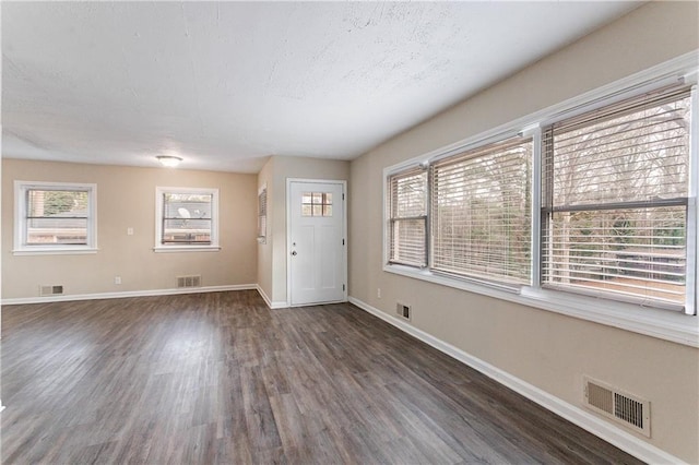 foyer entrance featuring a textured ceiling and dark hardwood / wood-style flooring