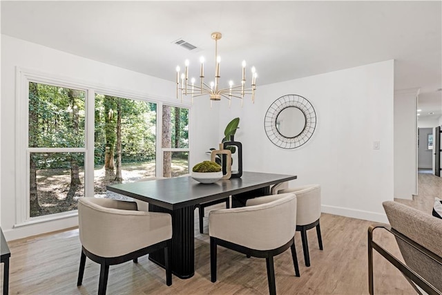 dining room with baseboards, an inviting chandelier, visible vents, and light wood-type flooring
