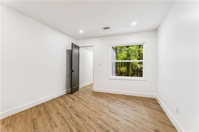 unfurnished room featuring recessed lighting, light wood-style flooring, visible vents, and baseboards