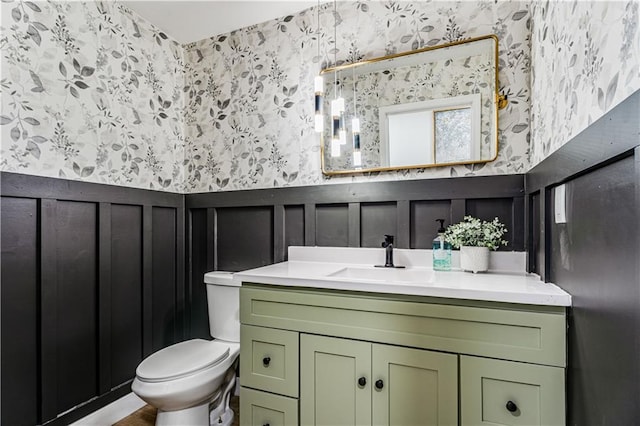 bathroom featuring wallpapered walls, toilet, and vanity