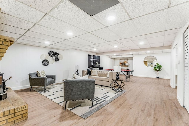 living area with recessed lighting, wood finished floors, a wood stove, and baseboards