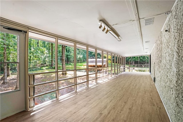 unfurnished sunroom featuring plenty of natural light and visible vents