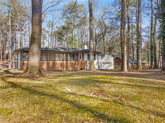 exterior space with a chimney, a sunroom, and a front yard