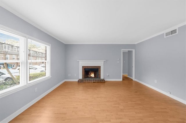 unfurnished living room with a brick fireplace, light wood-style flooring, visible vents, and baseboards