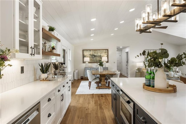 221 Brooke Dr, Alpharetta, GA 30009 - kitchen with lofted ceiling, light countertops, appliances with stainless steel finishes, white cabinetry, and hardwood / wood-style floors