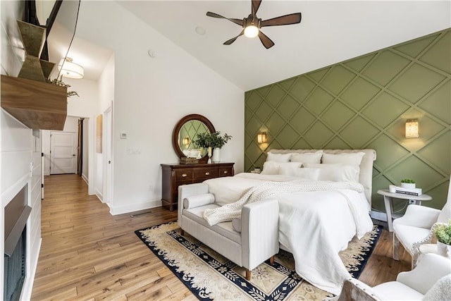 221 Brooke Dr, Alpharetta, GA 30009 - bedroom with an accent wall, baseboards, a decorative wall, light wood-style floors, and high vaulted ceiling
