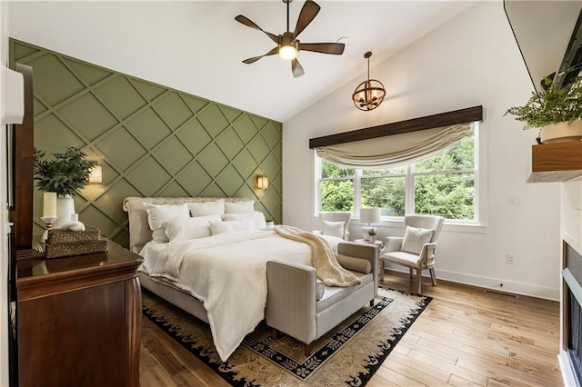 221 Brooke Dr, Alpharetta, GA 30009 - bedroom featuring an accent wall, baseboards, lofted ceiling, a fireplace, and light wood-style flooring