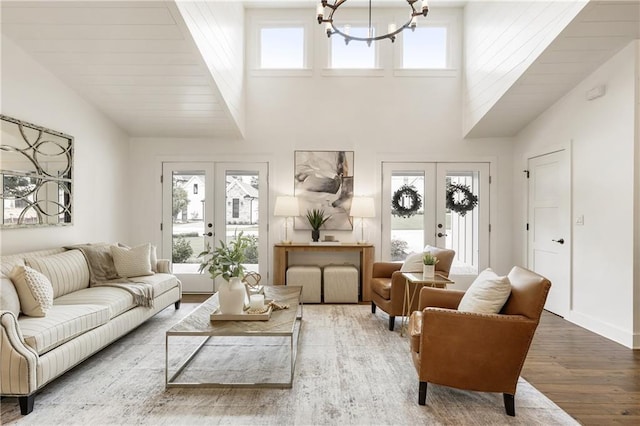221 Brooke Dr, Alpharetta, GA 30009 - living area featuring french doors, wood finished floors, a chandelier, plenty of natural light, and high vaulted ceiling