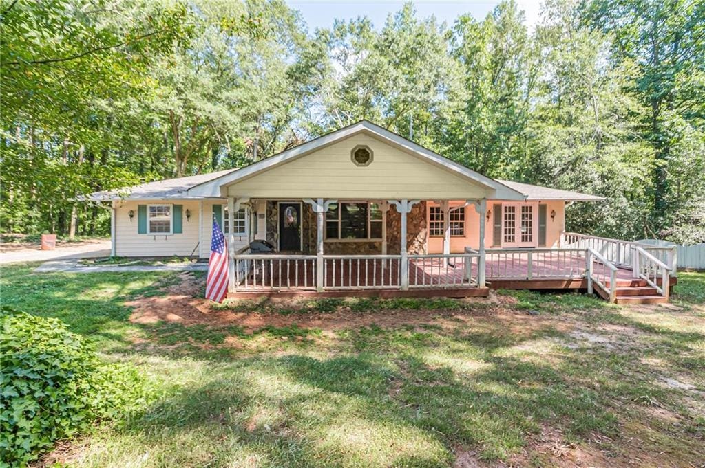 single story home with a front lawn and a deck