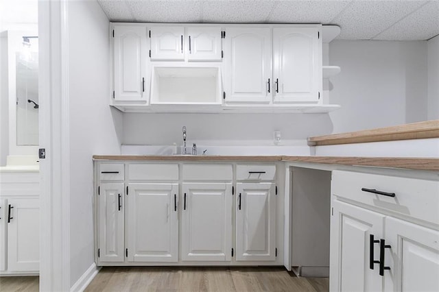 1706 Brandon Lee Way SW, Marietta, GA 30008 - kitchen featuring open shelves, light countertops, white cabinets, light wood-style floors, and a drop ceiling