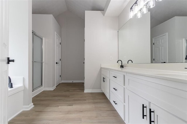 1706 Brandon Lee Way SW, Marietta, GA 30008 - bathroom with double vanity, wood finished floors, a shower with door, baseboards, and lofted ceiling