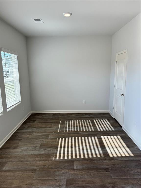 empty room with dark hardwood / wood-style flooring