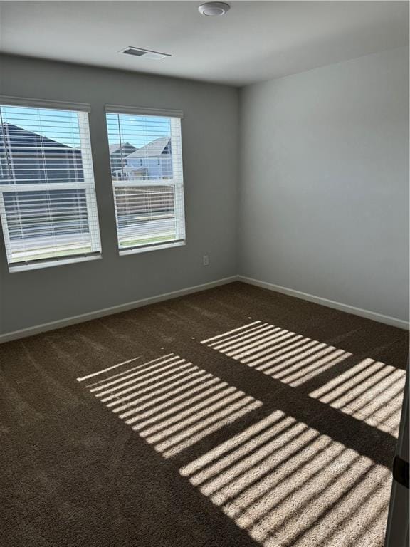 unfurnished room with dark carpet