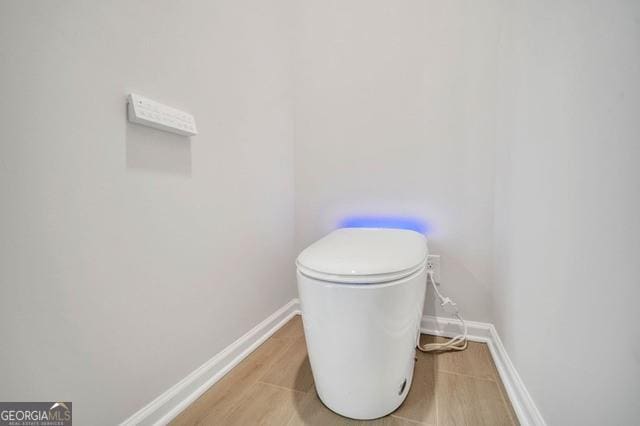 bathroom featuring toilet and wood-type flooring