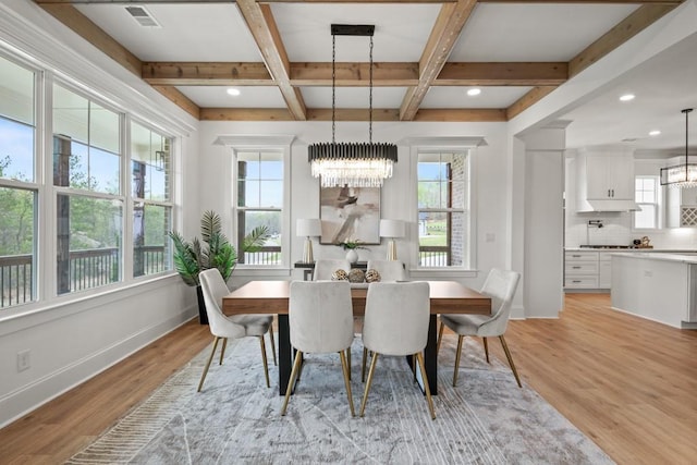 dining space with a notable chandelier, coffered ceiling, baseboards, and light wood-type flooring